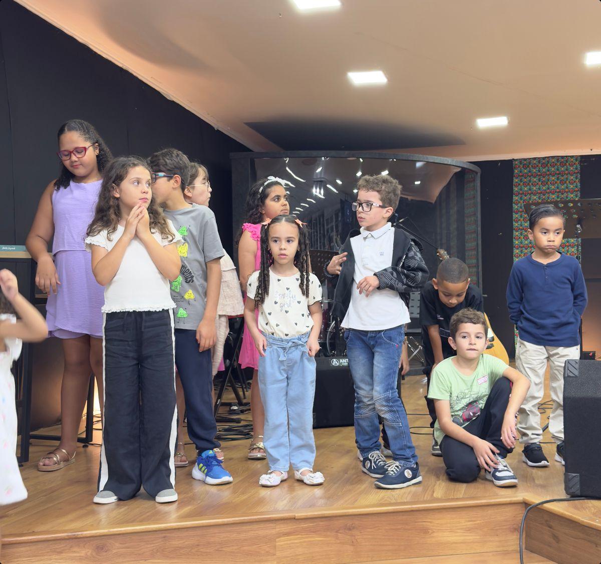Crianças da IBQ reunidas no palco durante uma celebração